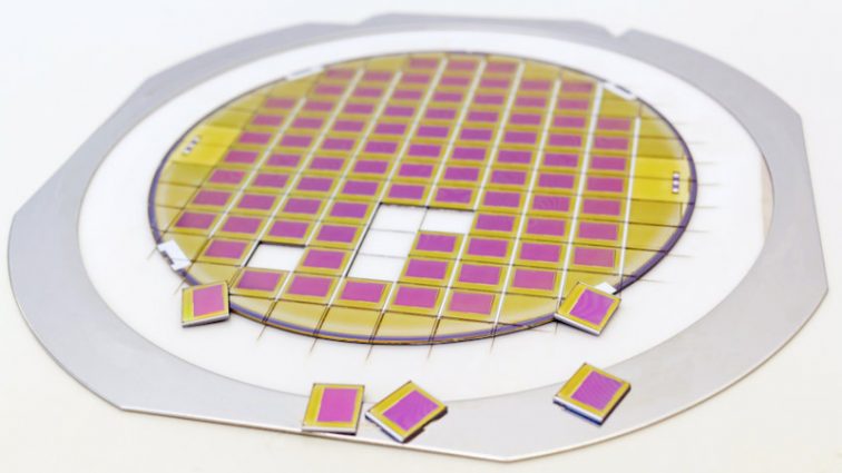 Silicon wafer with microchips fixed in a holder with a steel frame after the dicing process and separate microchips. Silicon Wafers with microchips - used in electronics for the fabrication of integrated circuits.Color silicon wafers with glare.